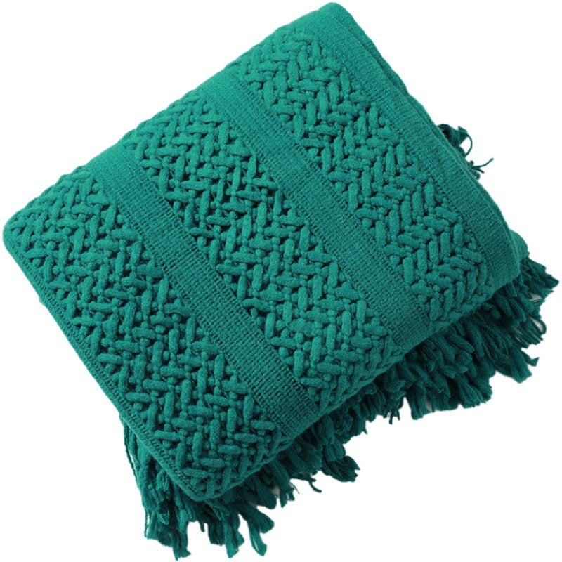 Plaid nordique tricoté vert émeraude plié sur fond blanc