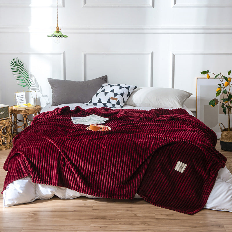 Plaid en flanelle bordeaux côtelé disposé sur un lit