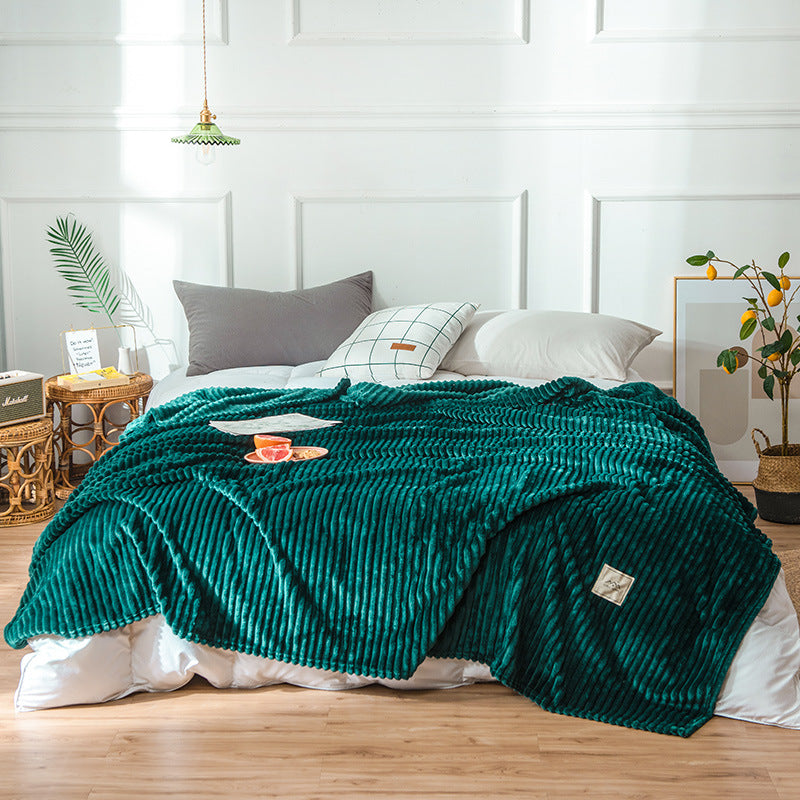 Plaid en flanelle vert émeraude côtelé disposé sur un lit