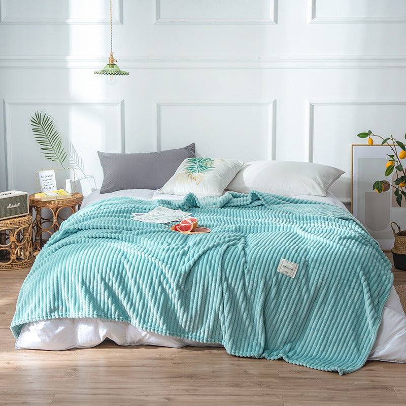 Plaid en flanelle bleu clair côtelé disposé sur un lit