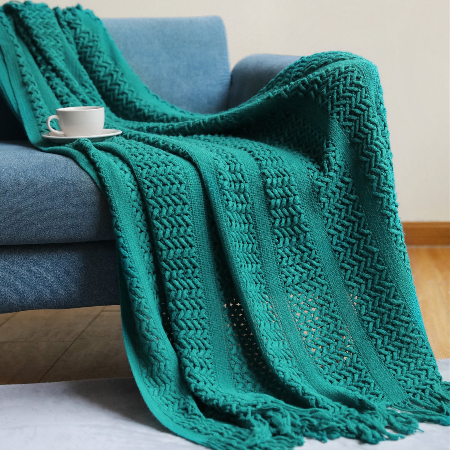 Plaid nordique tricoté vert émeraude sur un canapé bleu