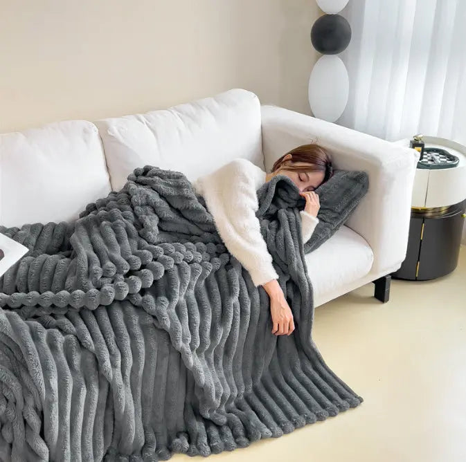 Plaid Douceur Nuage gris foncé utilisé sur un canapé blanc
