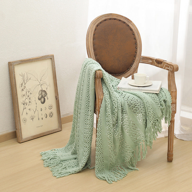 Plaid nordique tricoté vert lotus sur un fauteuil en bois