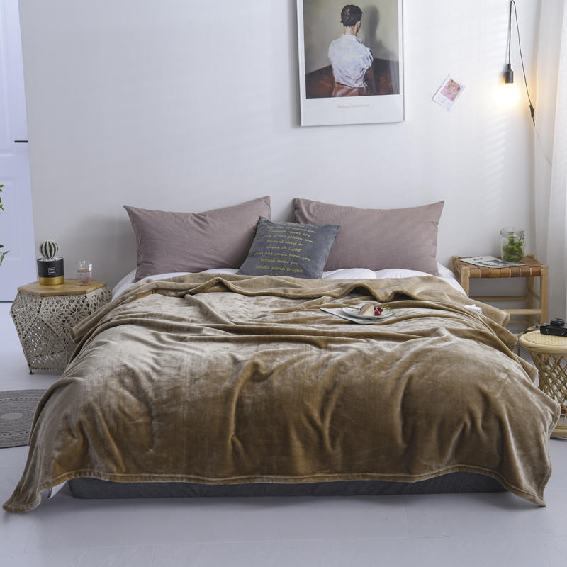 Plaid en flanelle taupe disposé sur un lit