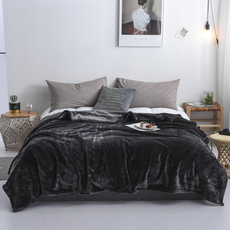 Plaid en flanelle gris anthracite disposé sur un lit
