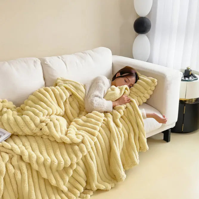 Plaid Douceur Nuage jaune pâle utilisé sur un canapé blanc